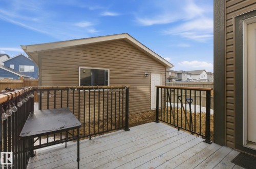 The property features a private deck with black metal railings and a wooden top rail - 17498 76 St Nw, Edmonton, AB - Outdoor With Deck Patio Veranda With Exterior