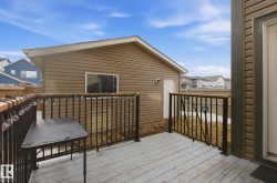 The property features a private deck with black metal railings and a wooden top rail - 
