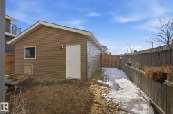 Detached garage with horizontal vinyl siding and a white exterior door - 