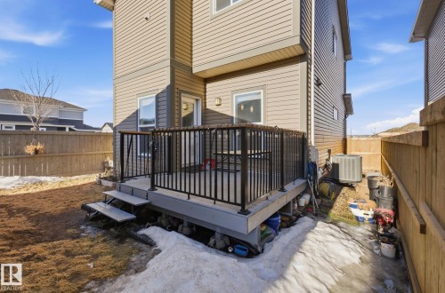 The property features a private deck with black railings and steps leading down to a fenced yard - 17498 76 St Nw, Edmonton, AB - Outdoor
