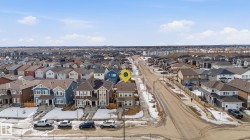 Aerial view of the neighborhood showcasing a variety of architectural styles and the property's location on a street with sidewalks - 