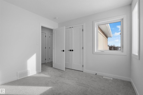 This room features light grey carpeting, white walls, and a window with a white frame - 3304 Chickadee Drive, Edmonton, AB - Indoor Photo Showing Other Room