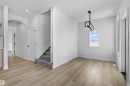 This interior features light-toned flooring, white walls, and a contemporary chandelier - 3304 Chickadee Drive, Edmonton, AB  - Indoor Photo Showing Other Room 