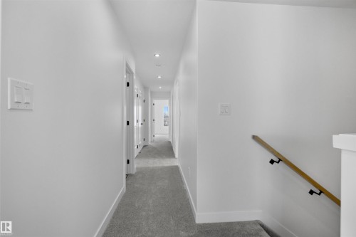 The property features a hallway with recessed lighting and light gray carpeting, complemented by white walls and trim - 3304 Chickadee Drive, Edmonton, AB - Indoor Photo Showing Other Room