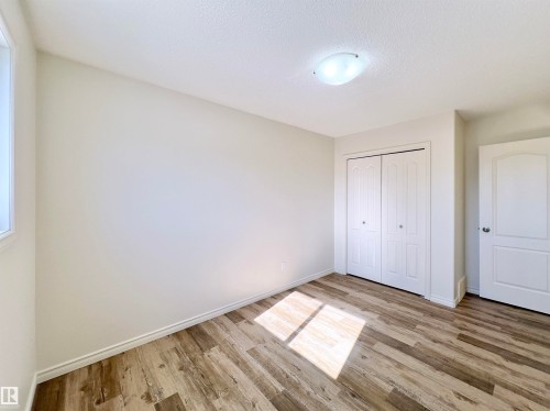 The room features light-toned walls, wood-style flooring, a window, and a ceiling-mounted light fixture - 17127 7A Avenue, Edmonton, AB - Indoor Photo Showing Other Room