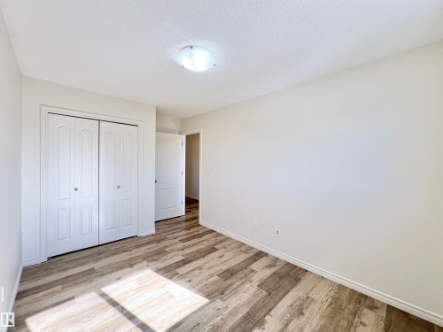 This property features a room with light-colored walls and wood-look flooring - 17127 7A Avenue, Edmonton, AB - Indoor Photo Showing Other Room