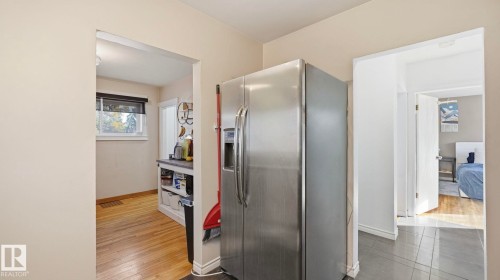 The property features a stainless steel refrigerator with a water and ice dispenser - 10922 117 Street, Edmonton, AB - Indoor Photo Showing Other Room