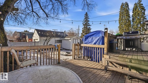 The property features a tiered wooden deck with railings, offering an outdoor entertainment area - 10922 117 Street, Edmonton, AB - Outdoor With Deck Patio Veranda