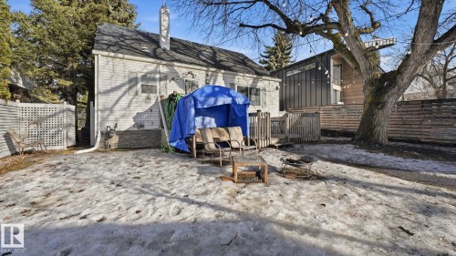 The property features a fenced yard, a wooden deck, and a fire pit area - 10922 117 Street, Edmonton, AB - Outdoor