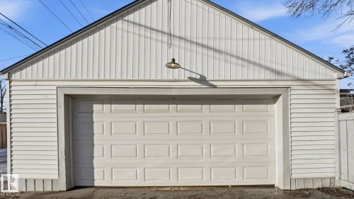 The property features a garage with white siding and a white garage door - 10922 117 Street, Edmonton, AB - Outdoor With Exterior