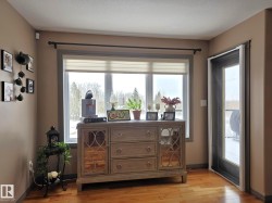 The property features hardwood floors and a large window with a view of mature trees - 