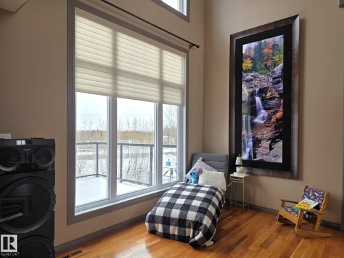 This room features hardwood floors, a large window with privacy blinds, and light-colored walls - 4477 36 Street, Drayton Valley, AB - Indoor Photo Showing Bedroom