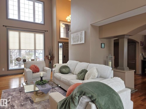 The living area features high ceilings, hardwood flooring, and large windows that provide natural light - 4477 36 Street, Drayton Valley, AB - Indoor Photo Showing Living Room