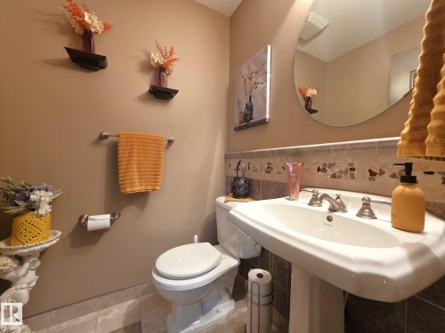 Bathroom featuring a pedestal sink, tiled backsplash, and a wall-mounted mirror - 4477 36 Street, Drayton Valley, AB - Indoor Photo Showing Bathroom