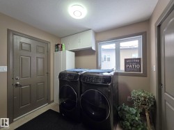 Laundry area featuring overhead cabinetry, a window, and a door - 