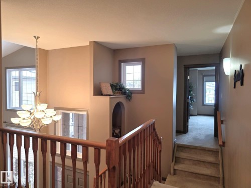 The property features a staircase with wooden railings and carpeted steps - 4477 36 Street, Drayton Valley, AB - Indoor Photo Showing Other Room