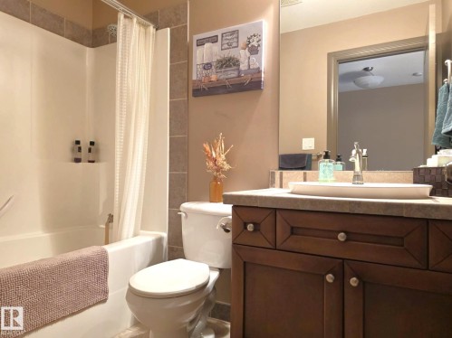 The bathroom features a bathtub with a shower, a toilet, and a vanity with a vessel sink - 4477 36 Street, Drayton Valley, AB - Indoor Photo Showing Bathroom
