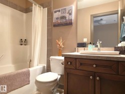 The bathroom features a bathtub with a shower, a toilet, and a vanity with a vessel sink - 