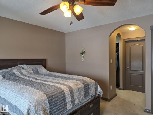 This property features a bedroom with a ceiling fan, neutral-toned walls, and carpeted flooring - 4477 36 Street, Drayton Valley, AB - Indoor Photo Showing Bedroom