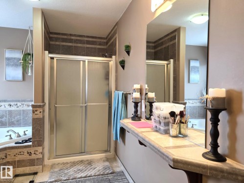 Bathroom featuring a glass-enclosed shower with tiled walls, a corner bathtub, and a spacious vanity with a large mirror - 4477 36 Street, Drayton Valley, AB - Indoor Photo Showing Bathroom