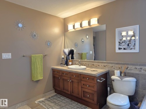 Bathroom with a wooden vanity featuring a white sink, a mirror, and overhead lighting - 4477 36 Street, Drayton Valley, AB - Indoor Photo Showing Bathroom