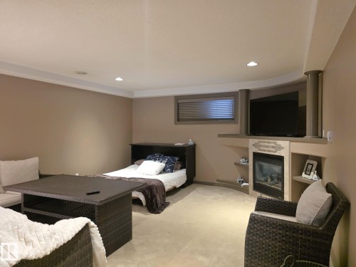 This room features recessed lighting, a fireplace with a decorative tile surround, and an integrated media shelf - 4477 36 Street, Drayton Valley, AB - Indoor With Fireplace