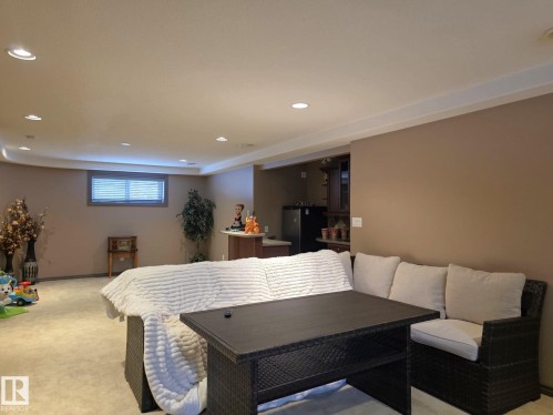 The property features a spacious room with recessed lighting and a window with horizontal blinds - 4477 36 Street, Drayton Valley, AB - Indoor