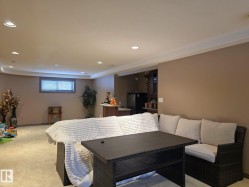 The property features a spacious room with recessed lighting and a window with horizontal blinds - 
