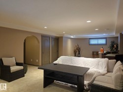 The property features a spacious living area with recessed lighting and neutral-toned walls - 