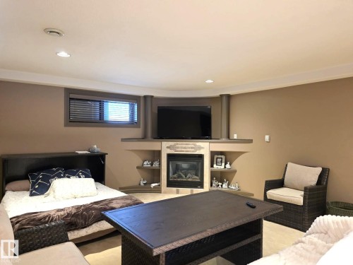 This versatile space features a built-in electric fireplace with decorative tiling and shelving, recessed lighting, and a window with blinds - 4477 36 Street, Drayton Valley, AB - Indoor With Fireplace
