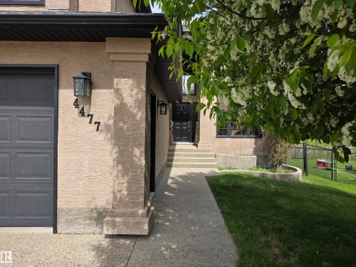 Stucco exterior with a dark gray garage door and black rain gutters - 4477 36 Street, Drayton Valley, AB - Outdoor
