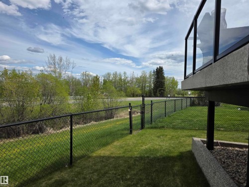 Expansive backyard featuring a manicured lawn, full chain-link fencing, and a private gate - 4477 36 Street, Drayton Valley, AB - Outdoor With View
