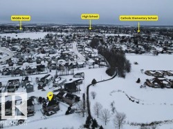 Aerial view of the property and its surrounding community, featuring a residential neighborhood with various homes and a paved pathway - 