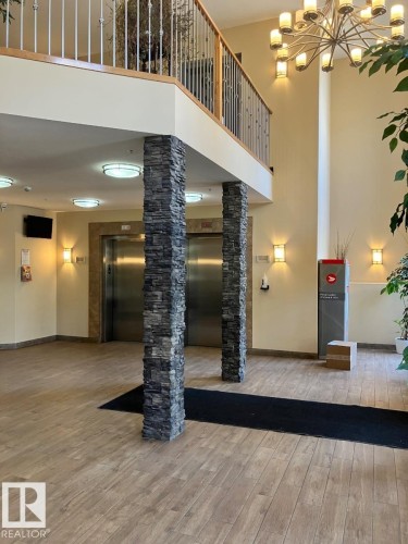 Entryway featuring wood-look flooring, stone-clad pillars, and recessed ceiling lighting - 145 10121 80 Avenue, Edmonton, AB - Indoor Photo Showing Other Room