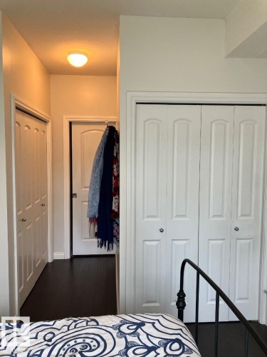 The property features dark flooring, white walls, and white closet doors - 145 10121 80 Avenue, Edmonton, AB - Indoor Photo Showing Bedroom