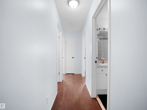 The interior hallway features hardwood flooring and light-colored walls - 13040 34 Street, Edmonton, AB - Indoor Photo Showing Other Room
