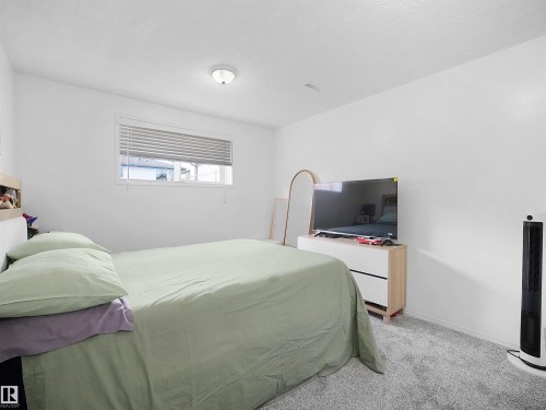 The property features a bright room with a window, white walls, and gray carpeting - 13040 34 Street, Edmonton, AB - Indoor Photo Showing Bedroom