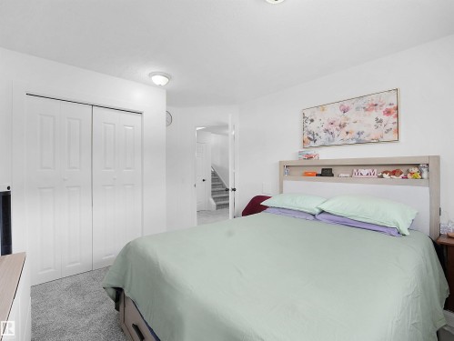 The room features white walls, ceiling, and bi-fold closet doors, with grey carpeting - 13040 34 Street, Edmonton, AB - Indoor Photo Showing Bedroom
