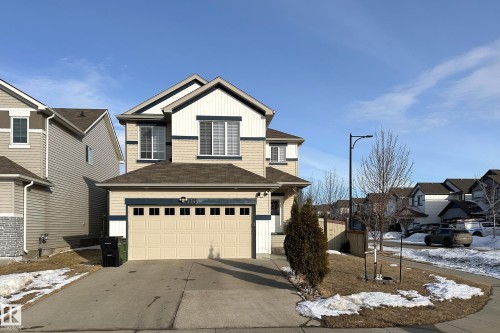 The property features a two-car garage, a paved driveway, and a front entrance with a small covered porch - 1743 60 Street Sw, Edmonton, AB - Outdoor