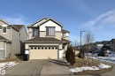The property features a two-car garage, a paved driveway, and a front entrance with a small covered porch - 1743 60 Street Sw, Edmonton, AB  - Outdoor 