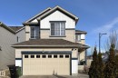 The property features an attached garage with a sectional door, light-colored siding with dark trim accents, and a sloped roof - 1743 60 Street Sw, Edmonton, AB  - Outdoor 