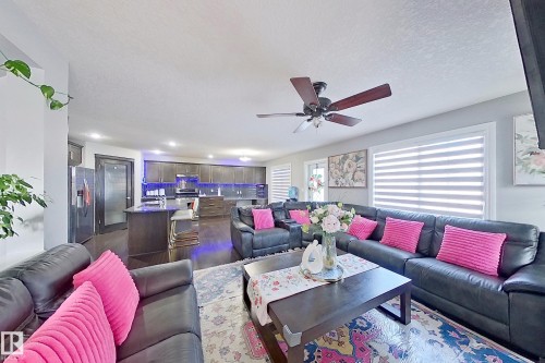 Spacious living area featuring dark hardwood floors, a ceiling fan, and large windows with blinds - 1743 60 Street Sw, Edmonton, AB - Indoor Photo Showing Living Room