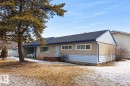 The property features a single-story structure with a blue shingle roof and a light-colored stucco exterior, accented by light blue siding - 13204 131A Avenue, Edmonton, AB  - Outdoor 