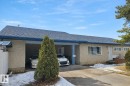 The property features a car port, a paved driveway, a white fence, and a pitched roof with blue gutters - 13204 131A Avenue, Edmonton, AB  - Outdoor 