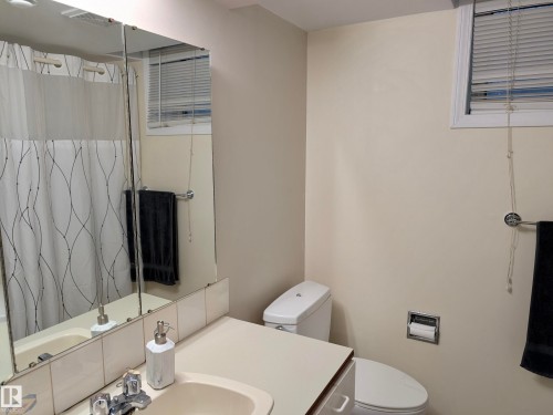 Bathroom featuring a vanity with a mirror, a toilet, and a window with blinds - 10645 65 Avenue, Edmonton, AB - Indoor Photo Showing Bathroom