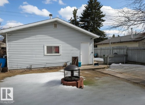 The property features a detached garage with light-colored siding and a side entry door - 10645 65 Avenue, Edmonton, AB - Outdoor