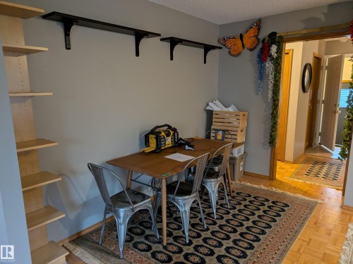 This versatile room features light grey walls, a wooden dining table, and a decorative area rug - 10645 65 Avenue, Edmonton, AB - Indoor