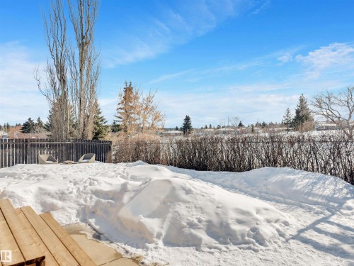 The property includes a spacious outdoor area with a wooden deck, a fenced yard, and mature trees - 131 West Liberty Crescent, Millet, AB - Outdoor