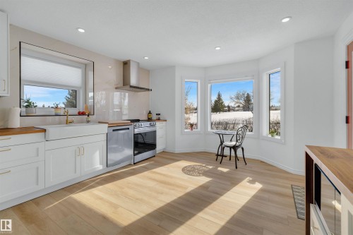 Bright kitchen featuring white cabinetry, light wood countertops, stainless steel appliances, and light wood flooring - 131 West Liberty Crescent, Millet, AB - Indoor Photo Showing Kitchen
