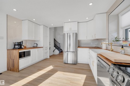 This kitchen features white cabinetry, wood countertops, and stainless steel appliances - 131 West Liberty Crescent, Millet, AB - Indoor Photo Showing Kitchen